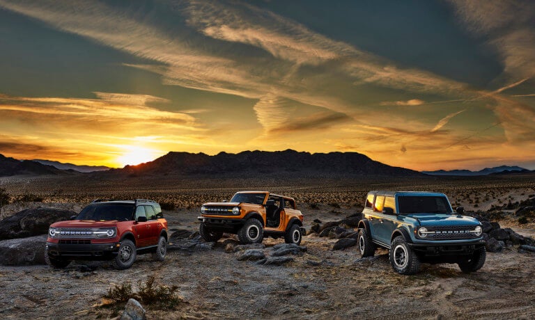 Three 2024 Ford Bronco Sports parked in desert at sunset