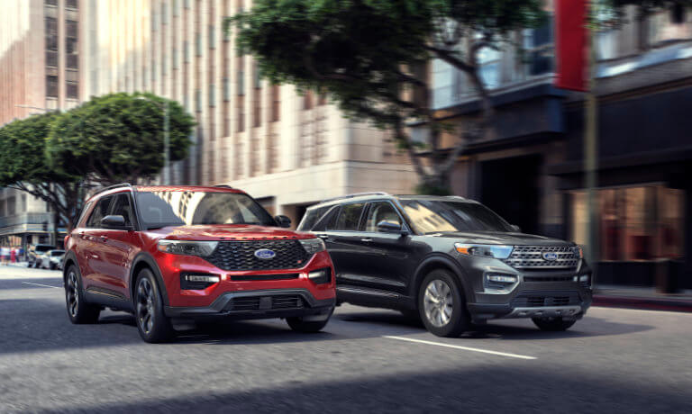 Two 2024 Ford Explorers driving side by side in city